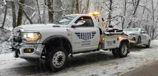 Elite Towing truck towing on a snowy road